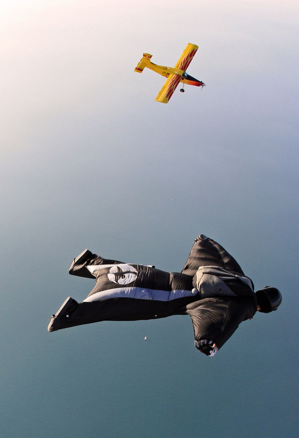 Pilote en wingsuit survolant Dubaï, avion d'accompagnement en arrière-plan